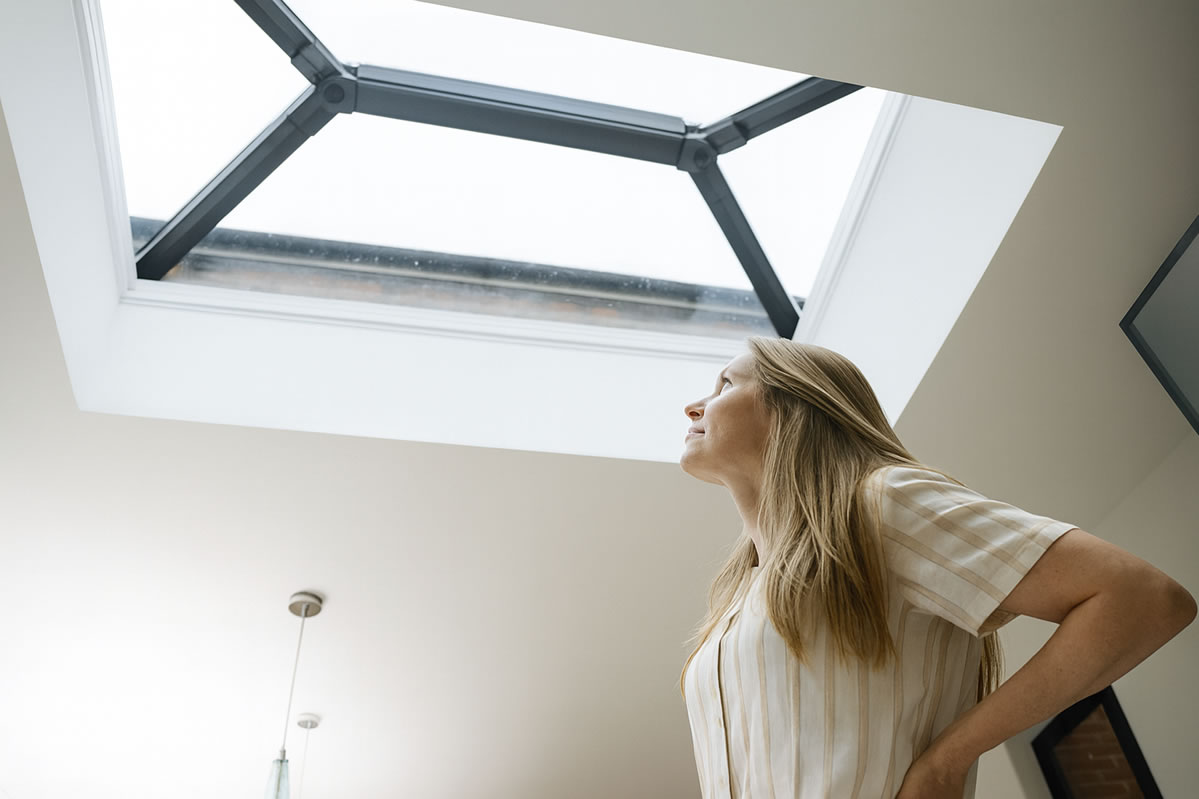 Woman looking up to skylight for repairs